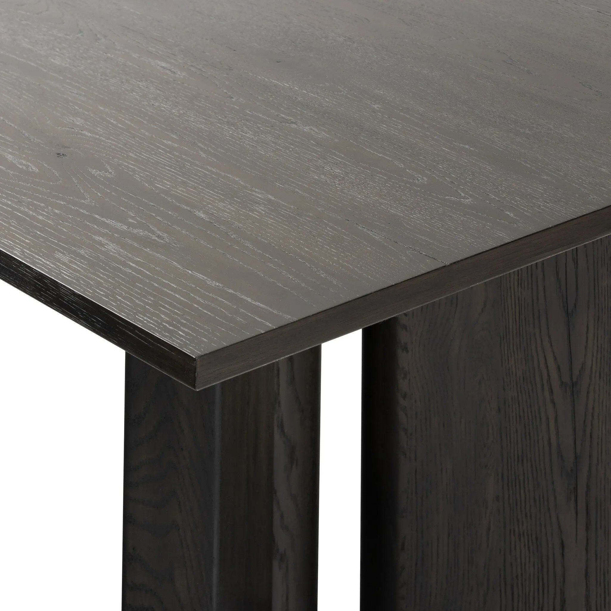 A smoked black finish brings character to this substantially sized dining table. Angled panel legs separated by a round cylinder craft a geometric look.Collection: Haide Amethyst Home provides interior design, new home construction design consulting, vintage area rugs, and lighting in the Newport Beach metro area.