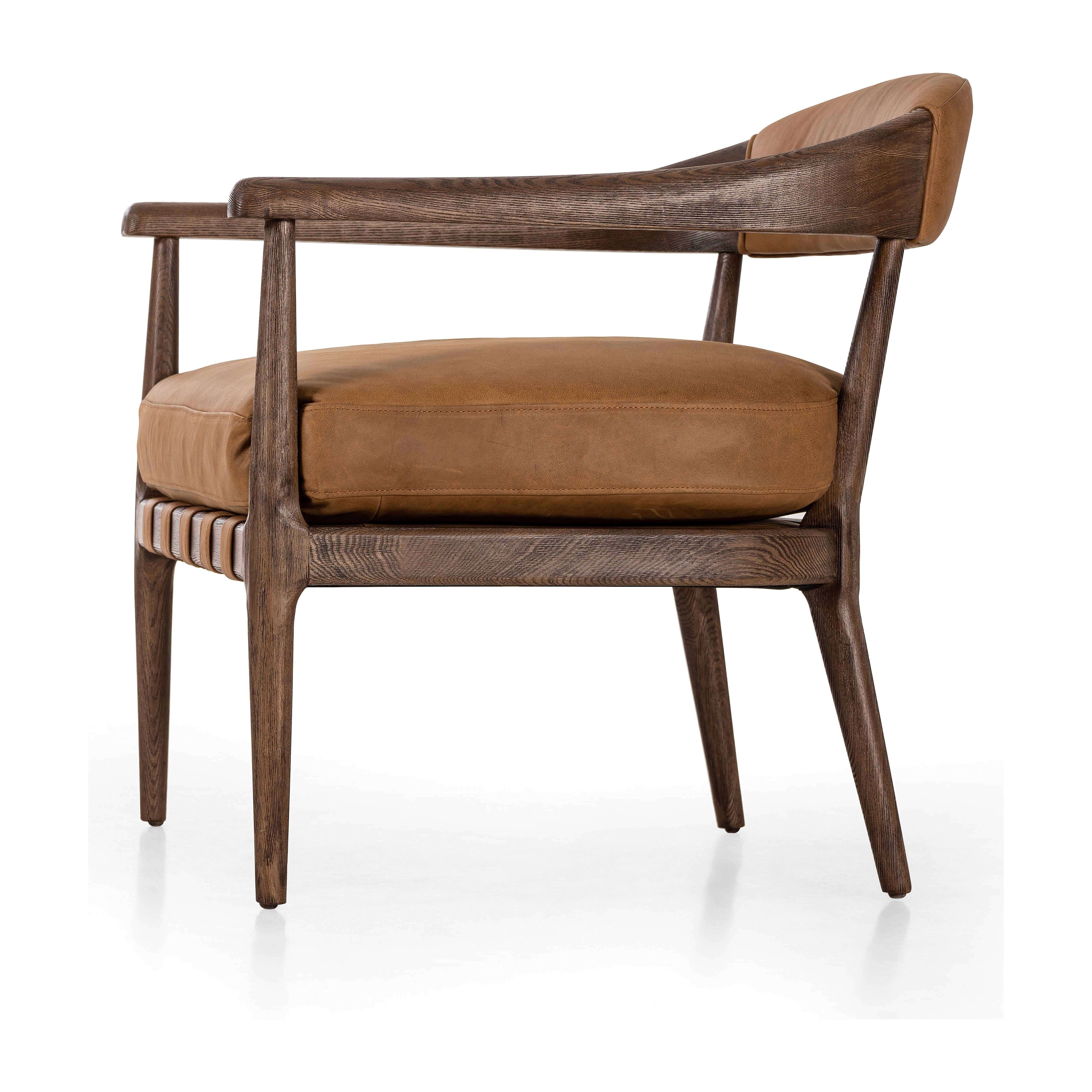 Safari styling is brought to modern speed on this vintage-inspired chair. Its solid wood frame features a webbed seating structure that brings a sink-in feel to the entire piece. The upholstered back, strap details and loose cushion are finished in carbon neutral, vegetable-tanned leather processed using naturally fallen eucalyptus leaves in Uruguay. Amethyst Home provides interior design, new construction, custom furniture, and area rugs in the Salt Lake City metro area.