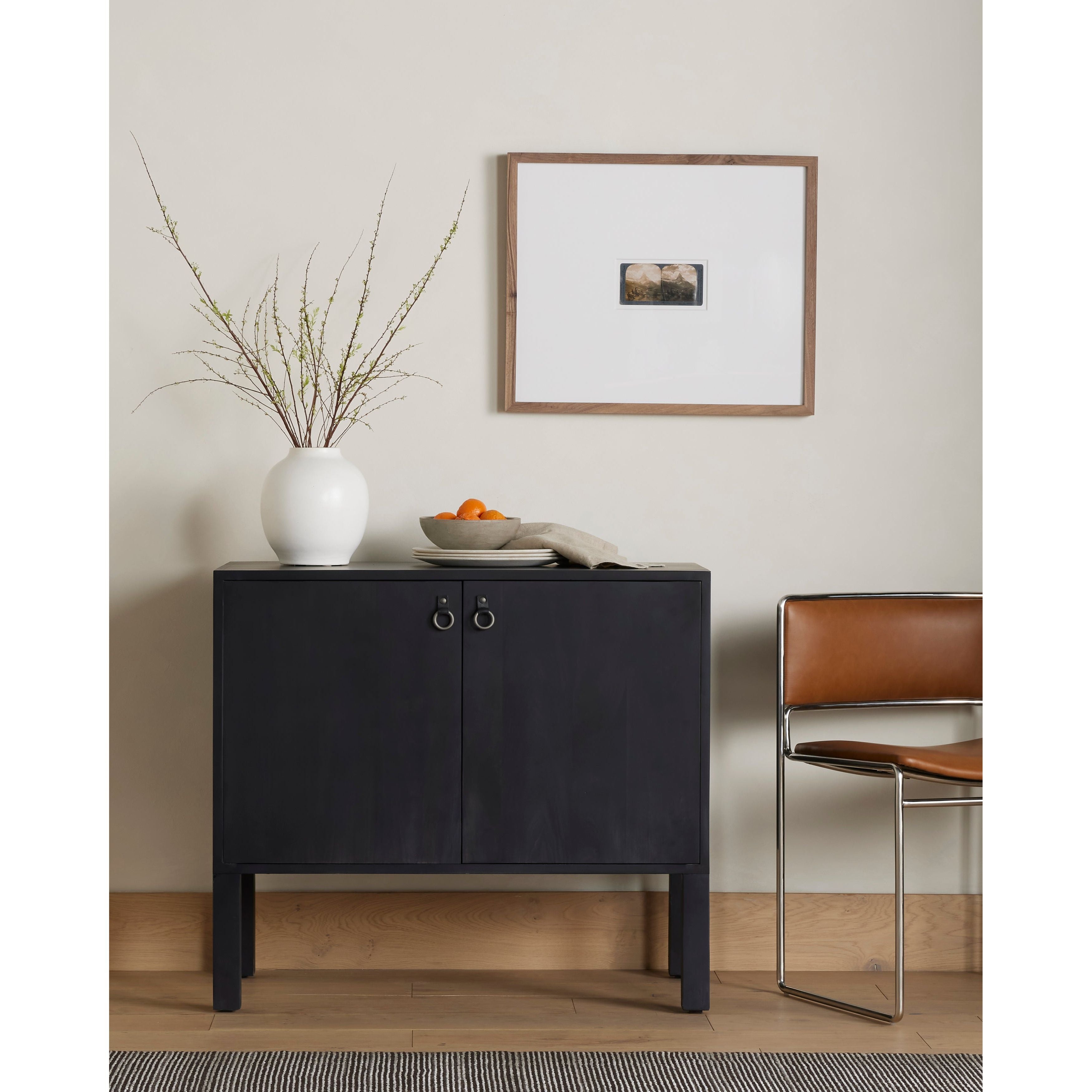 Beautifully simple in spirit. Black-washed solid poplar forms a Parsons-style bar cabinet, with iron and leather hardware for a material-driven update to Shaker-inspired styling. Inside, dual drawers plus generous bottle storage await drink go-tos and bar accessories. Amethyst Home provides interior design, new construction, custom furniture, and area rugs in the Boston metro area.