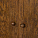 A beautifully simple statement piece. This three-door cabinet is crafted from a mix of solid oak and veneer in a dark toasted finish. Details include subtle, tapered corner posts and minimal rounded door knobs.Collection: Well Amethyst Home provides interior design, new home construction design consulting, vintage area rugs, and lighting in the Alpharetta metro area.