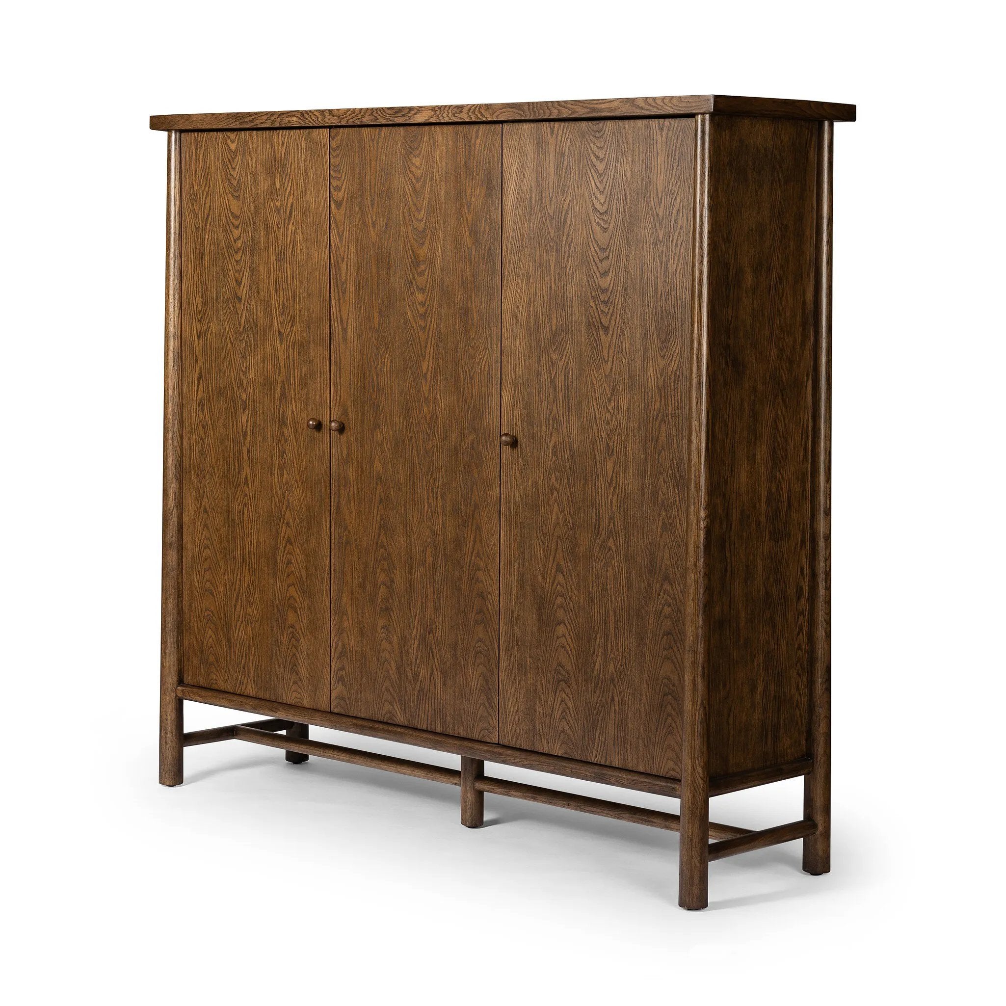 A beautifully simple statement piece. This three-door cabinet is crafted from a mix of solid oak and veneer in a dark toasted finish. Details include subtle, tapered corner posts and minimal rounded door knobs.Collection: Well Amethyst Home provides interior design, new home construction design consulting, vintage area rugs, and lighting in the Boston metro area.