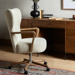 A comfort-driven desk chair features soft, textural upholstery, framed by solid ash arms. A height-adjustable swivel base with casters makes for ease in the modern office. Amethyst Home provides interior design, new home construction design consulting, vintage area rugs, and lighting in the Oklahoma City metro area.