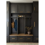 Dark gray mudroom with cabinets, hooks, and a small table.