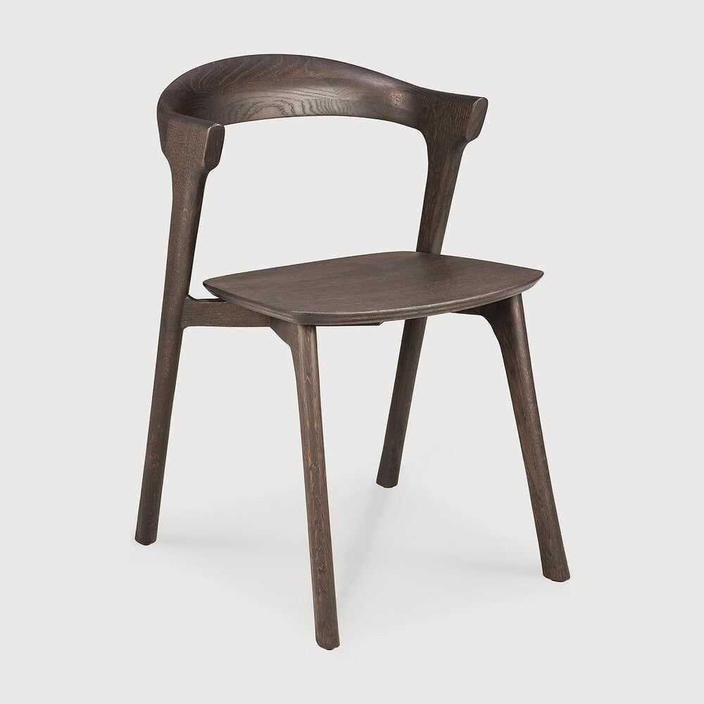 Over the years, the Bok dining chair has become one of our most recognisable designs. Designer Alain van Havre combines sculptural elegance and contemporary crafting into a graceful and airy form.

Seating height: 46cm - 18".
Made from brown tainted oak with a varnish finish. Amethyst Home provides interior design, new construction, custom furniture, and area rugs in the Houston metro area