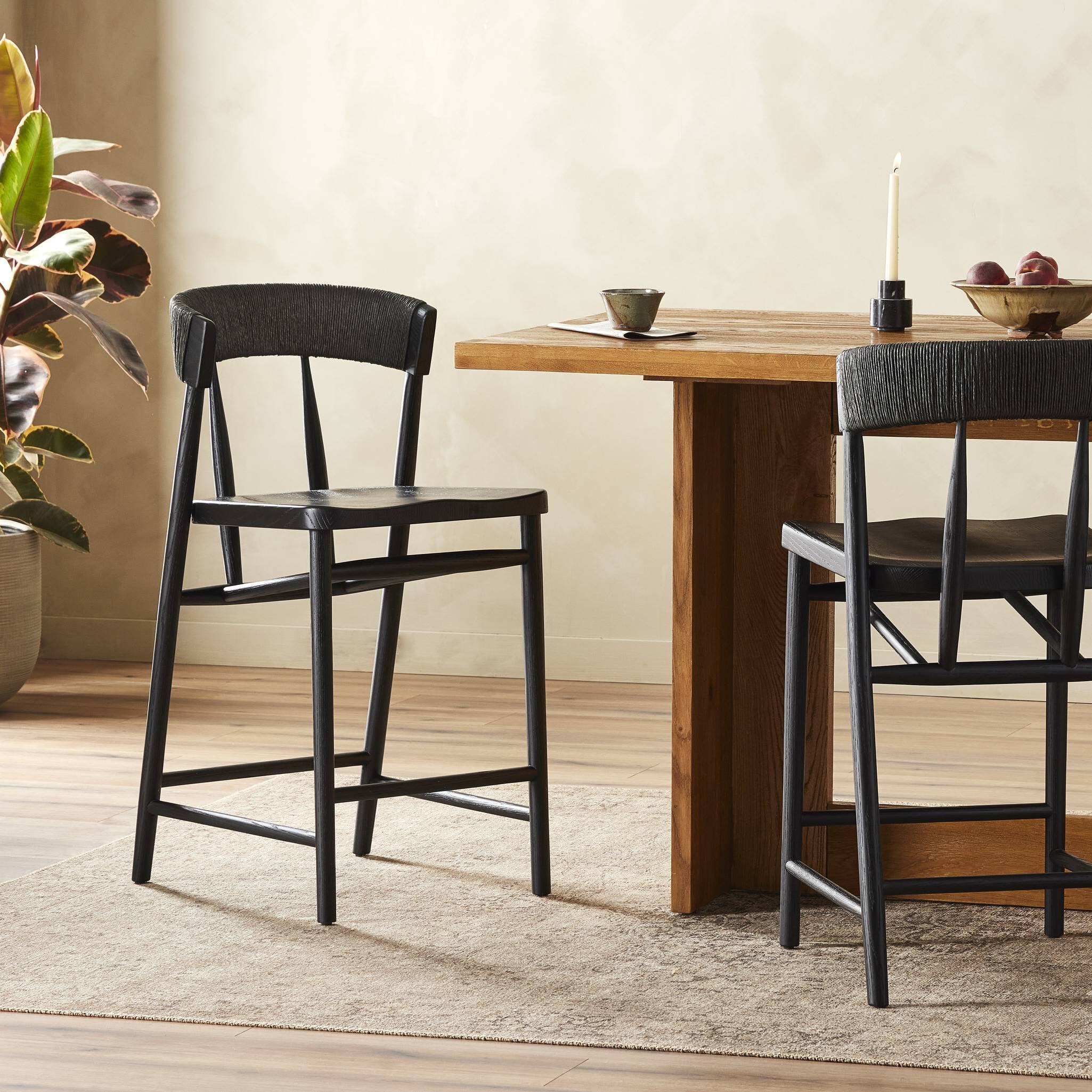 Featuring Buxton Black Rush Bar + Counter Stool by Four Hands at Amethyst Home. A solid oak counter stool defined by tapered legs and framing gives an updated look to the classic whistler chair. Finished with a paper rush wrapped detail on the back.BarOverall Dimensions: 19.25"w x 22.25"d x 42.75"hWeight: 23.70 lbsCounterOverall Dimensions: 19.50"w x 22.25"d x 38.75"hWeight: 21.61. Amethyst Home provides interior design, new construction, custom furniture, and area rugs in the Calabasas metro area