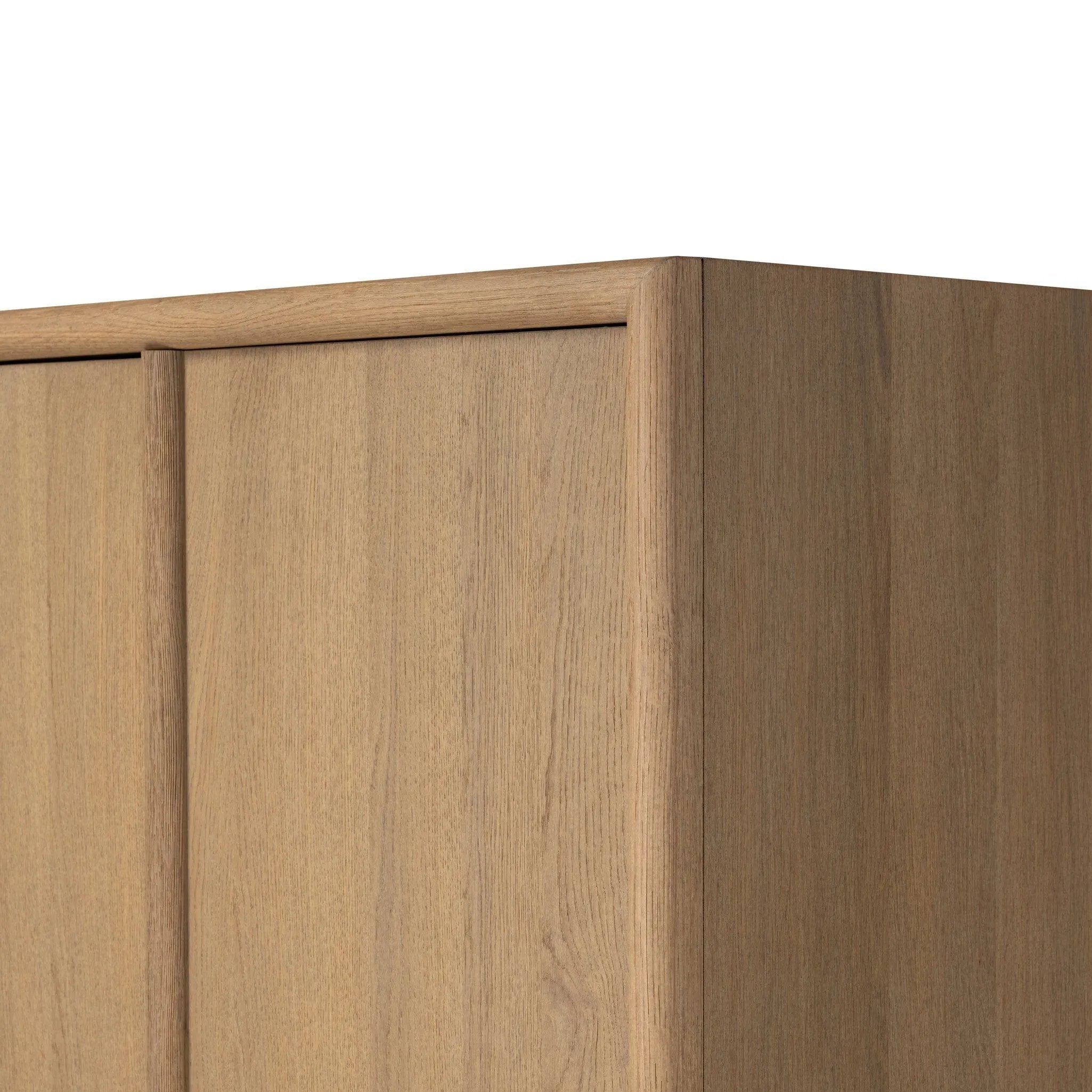 Crafted from sandy solid oak in a waterfall silhouette, this armoire adds a touch of contemporary simplicity to your bedroom. Double doors open to spacious shelving, complemented by a bottom drawer for extra storage. The piece’s bullnose edge and oval iron hardware add variety. Amethyst Home provides interior design, new home construction design consulting, vintage area rugs, and lighting in the Laguna Beach metro area.