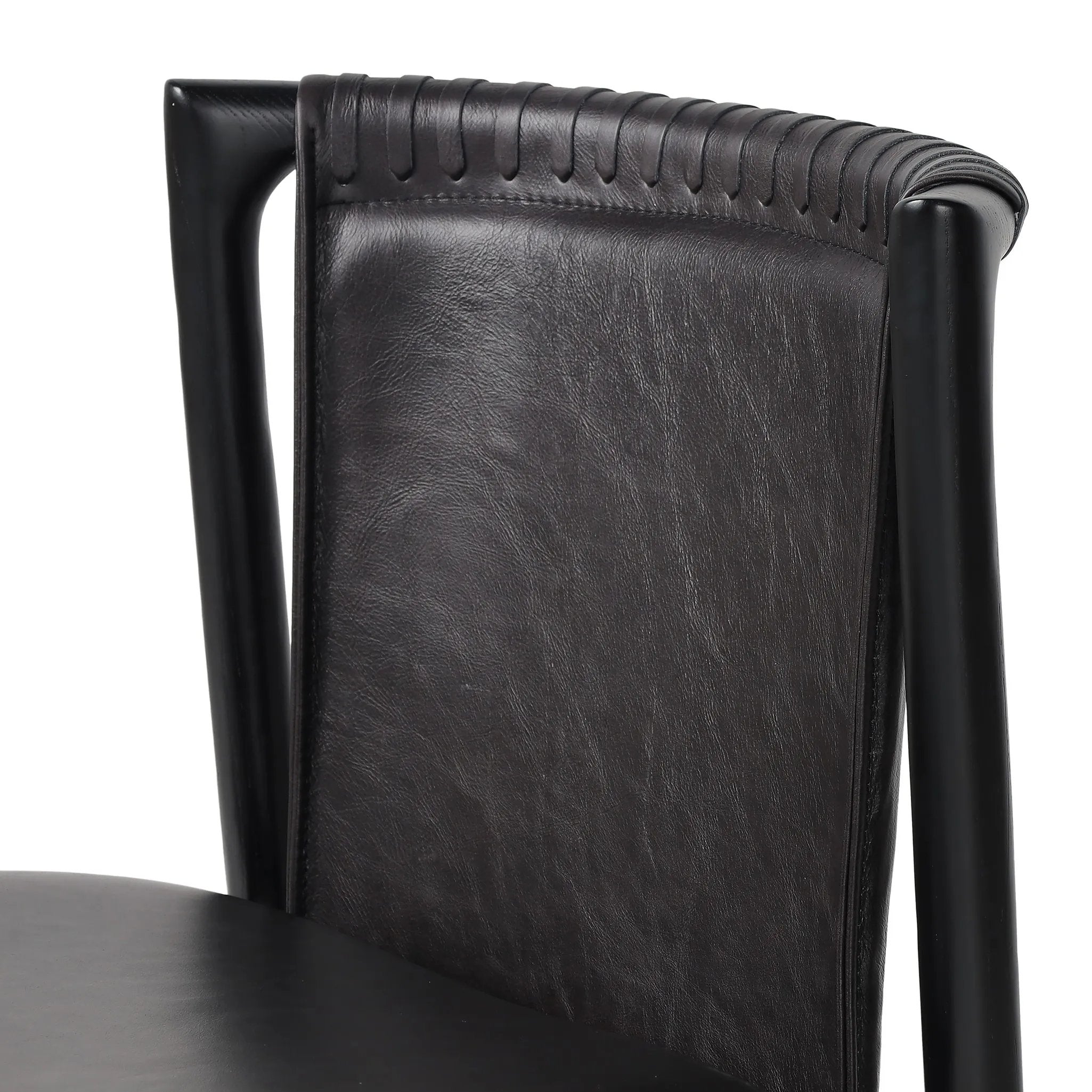 Featuring Baden Sonoma Black Dining Chair by Four Hands at Amethyst Home. Midcentury-inspired with its minimalist wooden frame, this armless dining chair features a low back and float-like seat upholstered in slightly distressed black top-grain leather exclusive to Four Hands. Leather wrap detailing for texture.Overall Dimensions: 19.75"w x 23.25"d x 32.25"hW. Amethyst Home provides interior design, new home construction design consulting, vintage area rugs, and lighting in the Houston metro area.