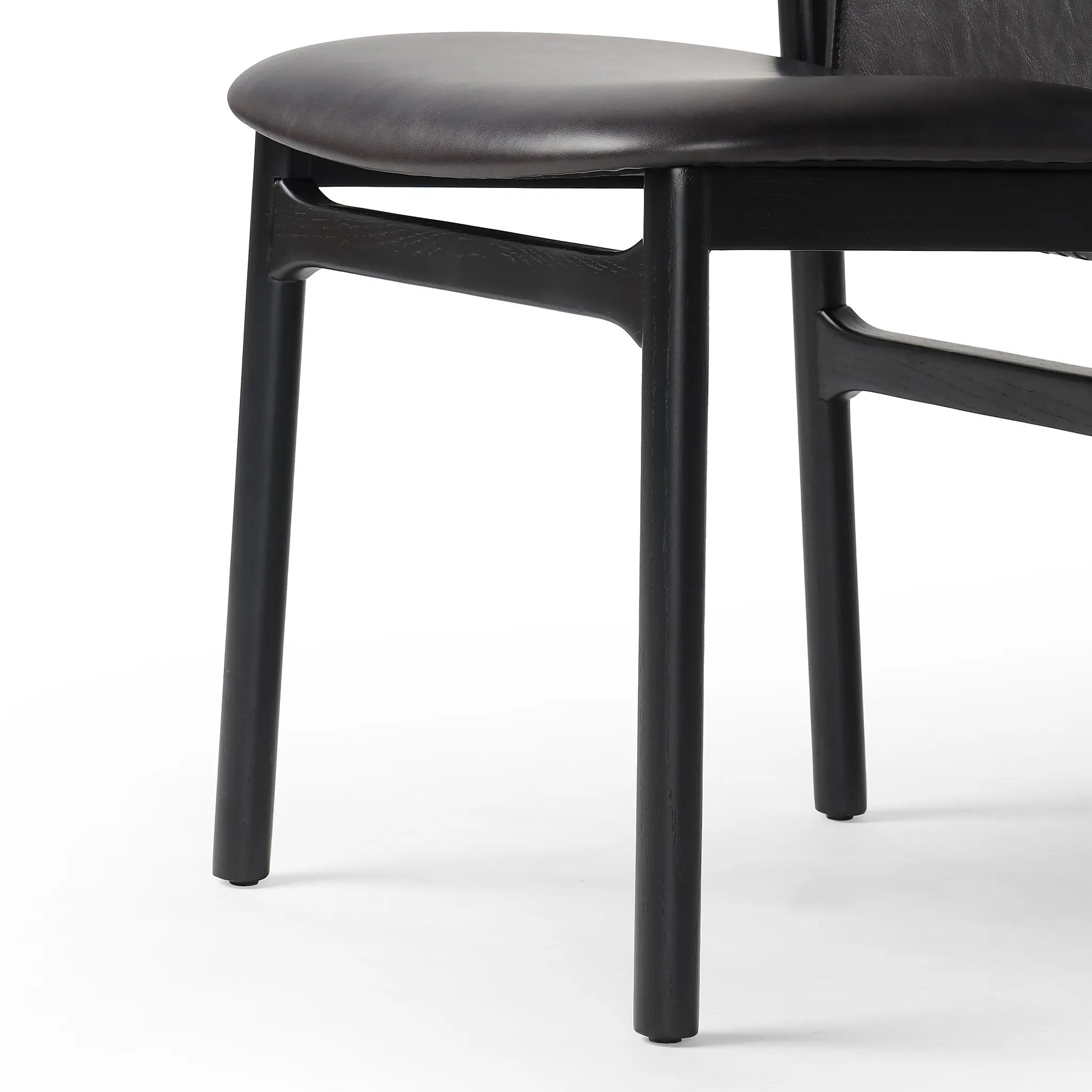 Featuring Baden Sonoma Black Dining Chair by Four Hands at Amethyst Home. Midcentury-inspired with its minimalist wooden frame, this armless dining chair features a low back and float-like seat upholstered in slightly distressed black top-grain leather exclusive to Four Hands. Leather wrap detailing for texture.Overall Dimensions: 19.75"w x 23.25"d x 32.2. Amethyst Home provides interior design, new home construction design consulting, vintage area rugs, and lighting in the Los Angeles metro area.