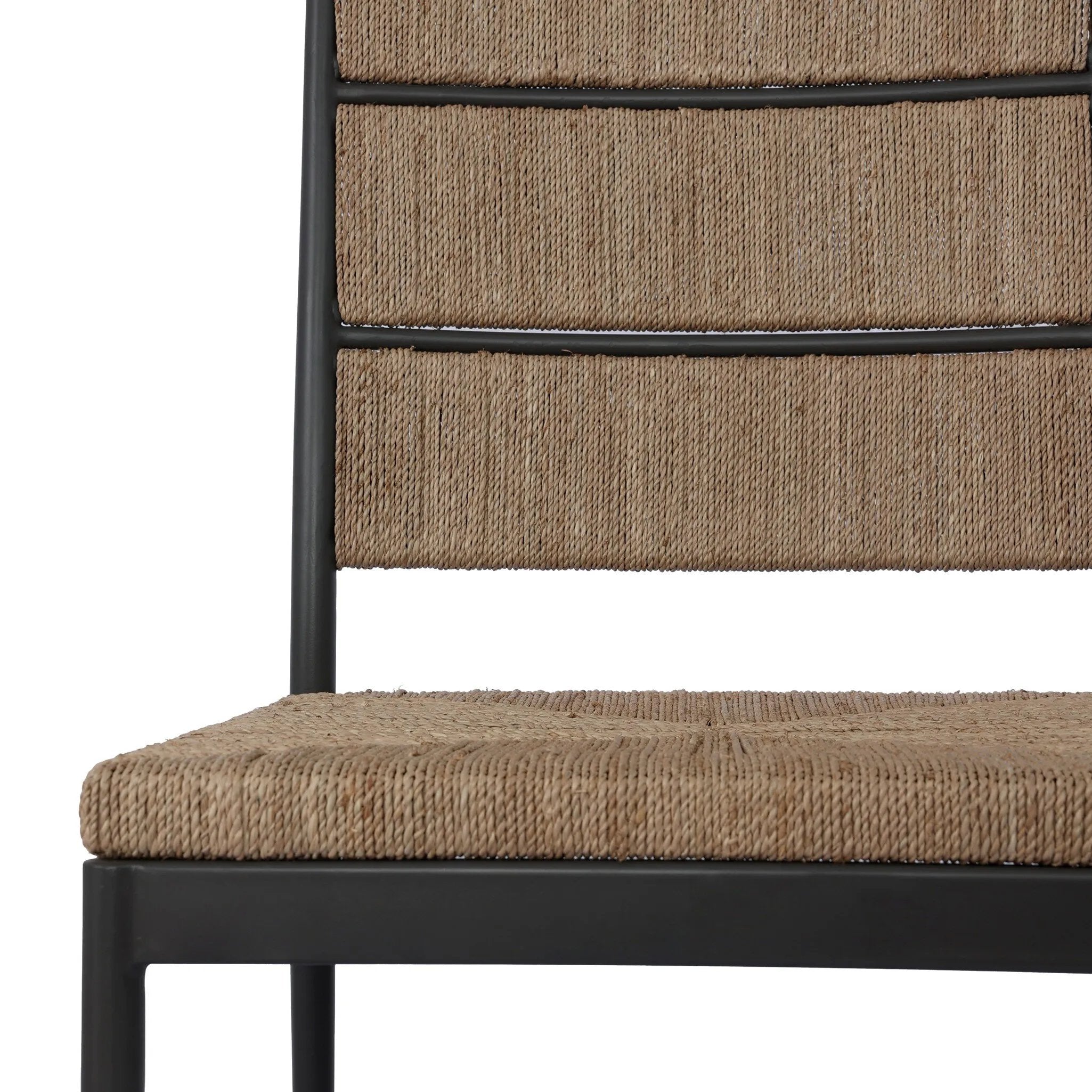 A steel dining chair frame is softened and paired with natural woven fibers. Thin, tapered legs and a tall channeled back cre