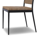 A steel dining chair frame is softened and paired with natural woven fibers. Thin, tapered legs and a tall channeled back cre