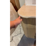 Fluid contours give shape to this solid mindi cabinet, topped with a creamy marbled top. Two doors with knobbed pulls open to