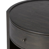 Rich contours bring character to the bedside. A round black-finished oak table has a spacious cubby and a single drawer with metal glides and a bronzed pull Amethyst Home provides interior design, new home construction design consulting, vintage area rugs, and lighting in the Alpharetta metro area.
