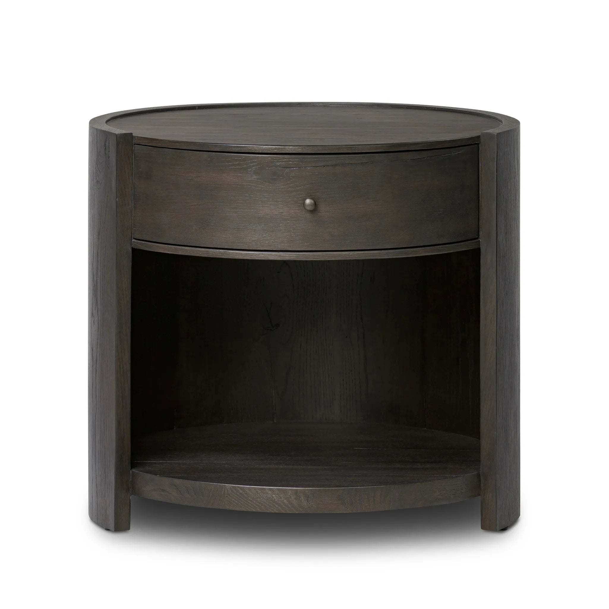 Rich contours bring character to the bedside. A round black-finished oak table has a spacious cubby and a single drawer with metal glides and a bronzed pull Amethyst Home provides interior design, new home construction design consulting, vintage area rugs, and lighting in the Salt Lake City metro area.