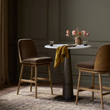 Solid ash wood forms a subtly curved back on this everyday counter stool. Its open frame and seat features rounded edges for 