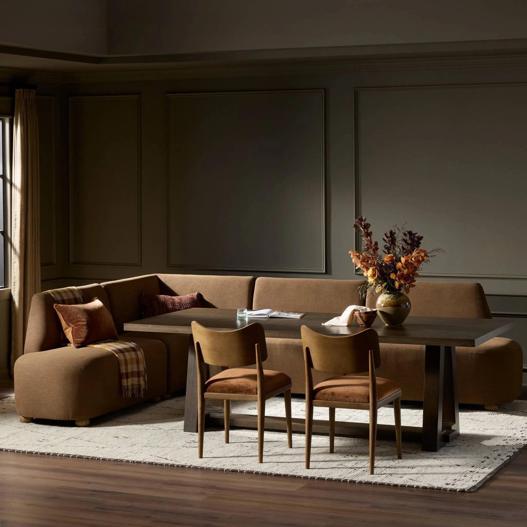 Dramatically shaped and tightly tailored, this rounded dining banquette features soft angles all around. Upholstered in a ver