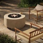 This outdoor fire table is a welcoming centerpiece designed for gathering. Made from glass-reinforced concrete, each piece is naturally finished with deep tones of pewter and dark grey. The monolithic shape is completed with lavastones in the center, bringing together a bold, monochromatic look. Amethyst Home provides interior design, new home construction design consulting, vintage area rugs, and lighting in the Houston metro area.