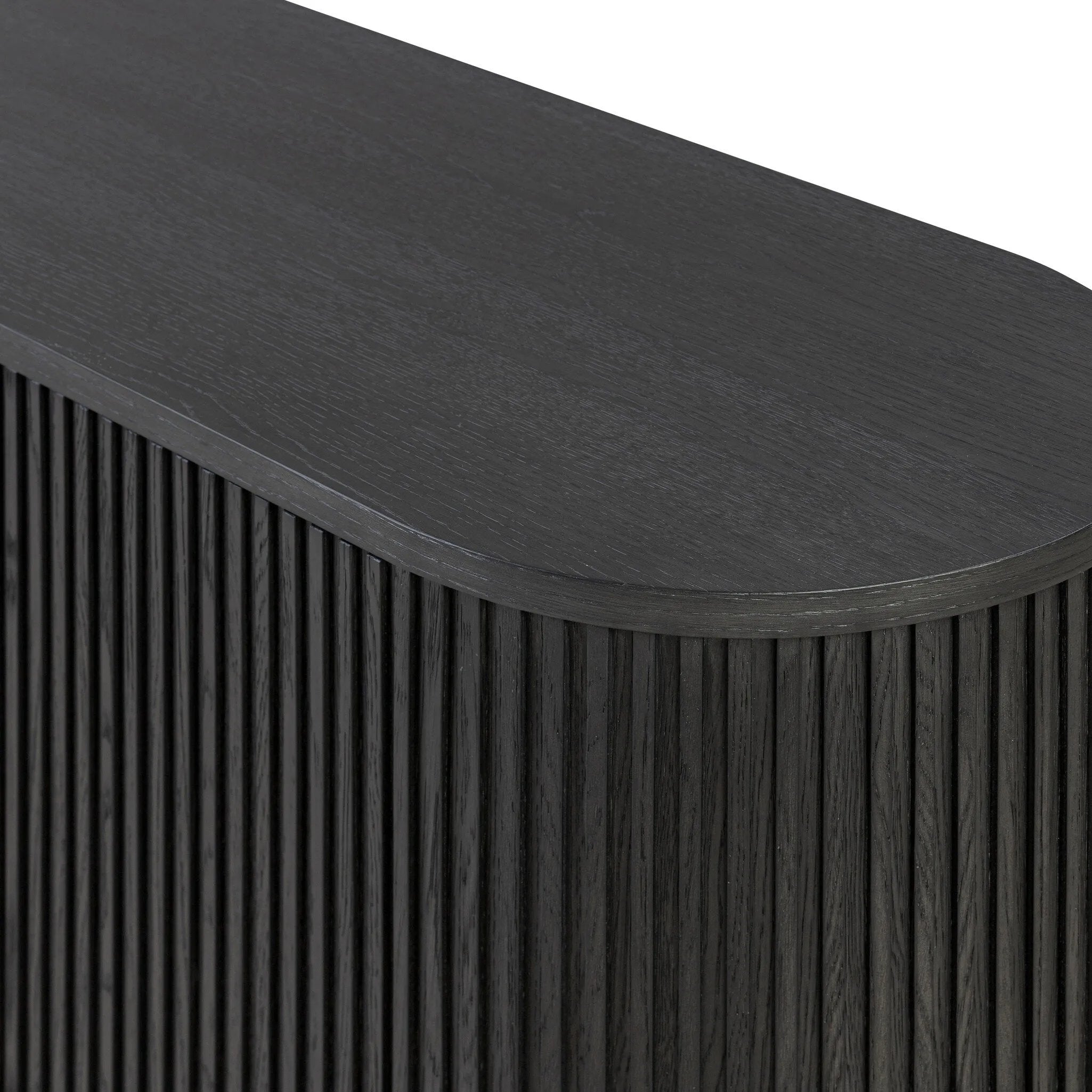 Crafted from desert oak solids and veneers with a plinth-style base, rounded sides and linear reeding, this sideboard exudes midcentury vibes. Fully finished interior and shelves for quality detailing inside and out.As enthusiasts of luxe style at Amethyst, we love the warm modern inspired Delphi Media Console - Cerused Black Oak. Amethyst Home provides interior design, new home construction design consulting, vintage area rugs, and lighting in the Los Angeles metro area.