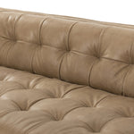 A modernized midcentury silhouette meets the traditional Chesterfield sofa, all in a compact profile perfect for smaller spaces. Top-grain leather in a tan hue, button tufting and a smooth touch bring deep comfort to lounging Amethyst Home provides interior design, new home construction design consulting, vintage area rugs, and lighting in the Charlotte metro area.