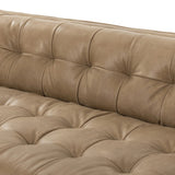 A modernized midcentury silhouette meets the traditional Chesterfield sofa, all in a compact profile perfect for smaller spaces. Top-grain leather in a tan hue, button tufting and a smooth touch bring deep comfort to lounging Amethyst Home provides interior design, new home construction design consulting, vintage area rugs, and lighting in the Charlotte metro area.