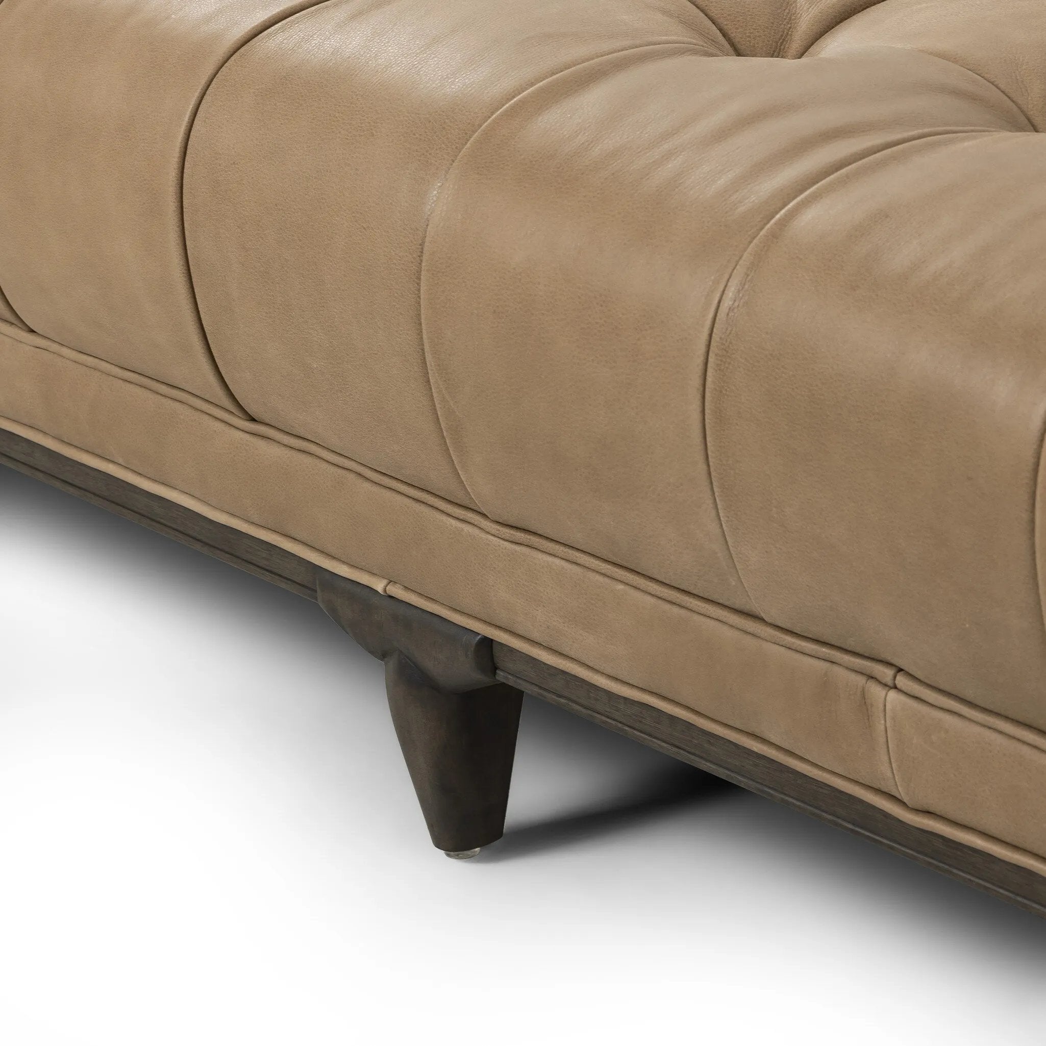 A modernized midcentury silhouette meets the traditional Chesterfield sofa, all in a compact profile perfect for smaller spaces. Top-grain leather in a tan hue, button tufting and a smooth touch bring deep comfort to lounging Amethyst Home provides interior design, new home construction design consulting, vintage area rugs, and lighting in the Houston metro area.