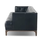 A modernized midcentury silhouette meets the traditional Chesterfield sofa, all in a compact profile perfect for smaller spaces. Top-grain leather in a classic black, button tufting and a smooth touch bring deep comfort to lounging Amethyst Home provides interior design, new home construction design consulting, vintage area rugs, and lighting in the Miami metro area.