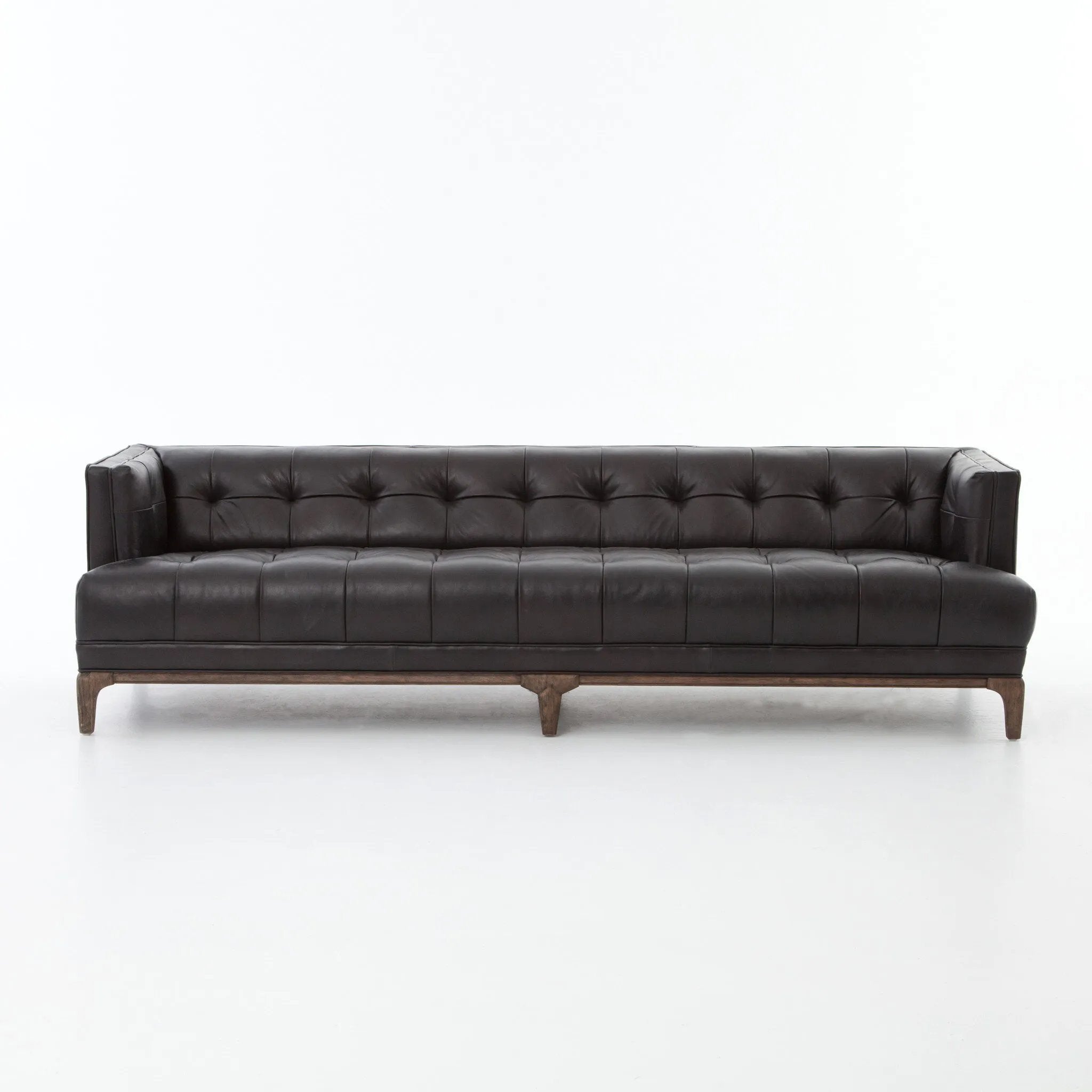 A modernized midcentury silhouette meets the traditional Chesterfield sofa, all in a compact profile perfect for smaller spaces. Top-grain leather in a classic black, button tufting and a smooth touch bring deep comfort to lounging Amethyst Home provides interior design, new home construction design consulting, vintage area rugs, and lighting in the San Diego metro area.