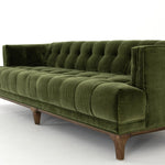 A modernized midcentury silhouette meets the traditional Chesterfield sofa, all in a compact profile perfect for smaller spaces. Smooth velvet in an olive hue, button tufting and a soft touch bring deep comfort to lounging Amethyst Home provides interior design, new home construction design consulting, vintage area rugs, and lighting in the Boston metro area.