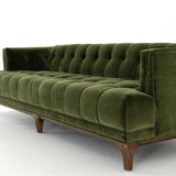 A modernized midcentury silhouette meets the traditional Chesterfield sofa, all in a compact profile perfect for smaller spaces. Smooth velvet in an olive hue, button tufting and a soft touch bring deep comfort to lounging Amethyst Home provides interior design, new home construction design consulting, vintage area rugs, and lighting in the Boston metro area.