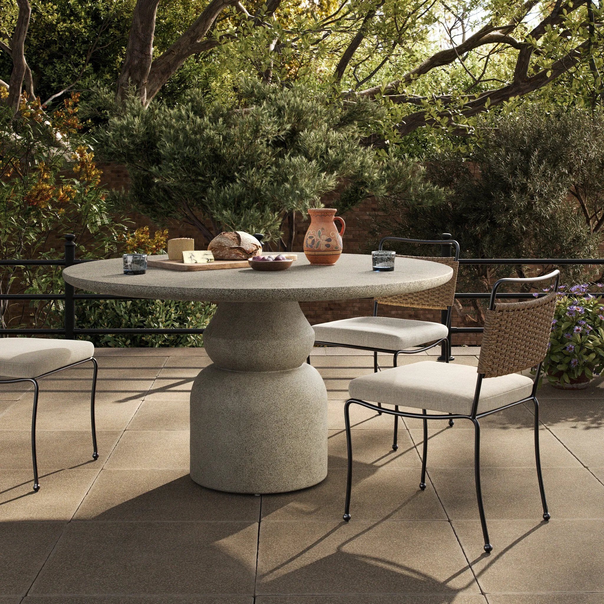 This outdoor dining table brings a fresh take to the classic pedestal silhouette. Shaped in an aged concrete that has lots of character and depth for an authentically weathered look. Cover or store inside during inclement weather and when not in use. Amethyst Home provides interior design, new home construction design consulting, vintage area rugs, and lighting in the Miami metro area.