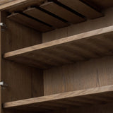 A rustic oak bar cabinet shapes subtly curved corners, bringing a handcrafted look to a minimalist form. Fixed center shelves, functional drawers and glass fronts for open display. Simple hardware is finished in an aged bronze Amethyst Home provides interior design, new home construction design consulting, vintage area rugs, and lighting in the Dallas metro area.