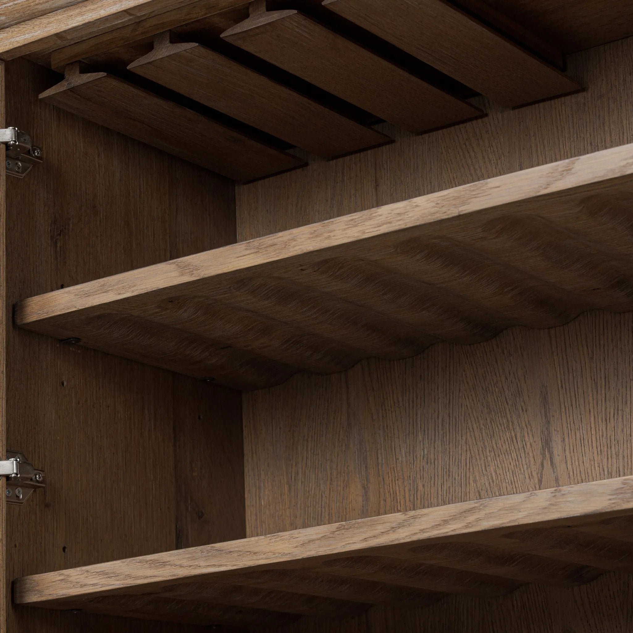 A rustic oak bar cabinet shapes subtly curved corners, bringing a handcrafted look to a minimalist form. Fixed center shelves, functional drawers and glass fronts for open display. Simple hardware is finished in an aged bronze Amethyst Home provides interior design, new home construction design consulting, vintage area rugs, and lighting in the Dallas metro area.