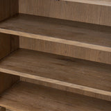 A rustic oak bar cabinet shapes subtly curved corners, bringing a handcrafted look to a minimalist form. Fixed center shelves, functional drawers and glass fronts for open display. Simple hardware is finished in an aged bronze Amethyst Home provides interior design, new home construction design consulting, vintage area rugs, and lighting in the Des Moines metro area.