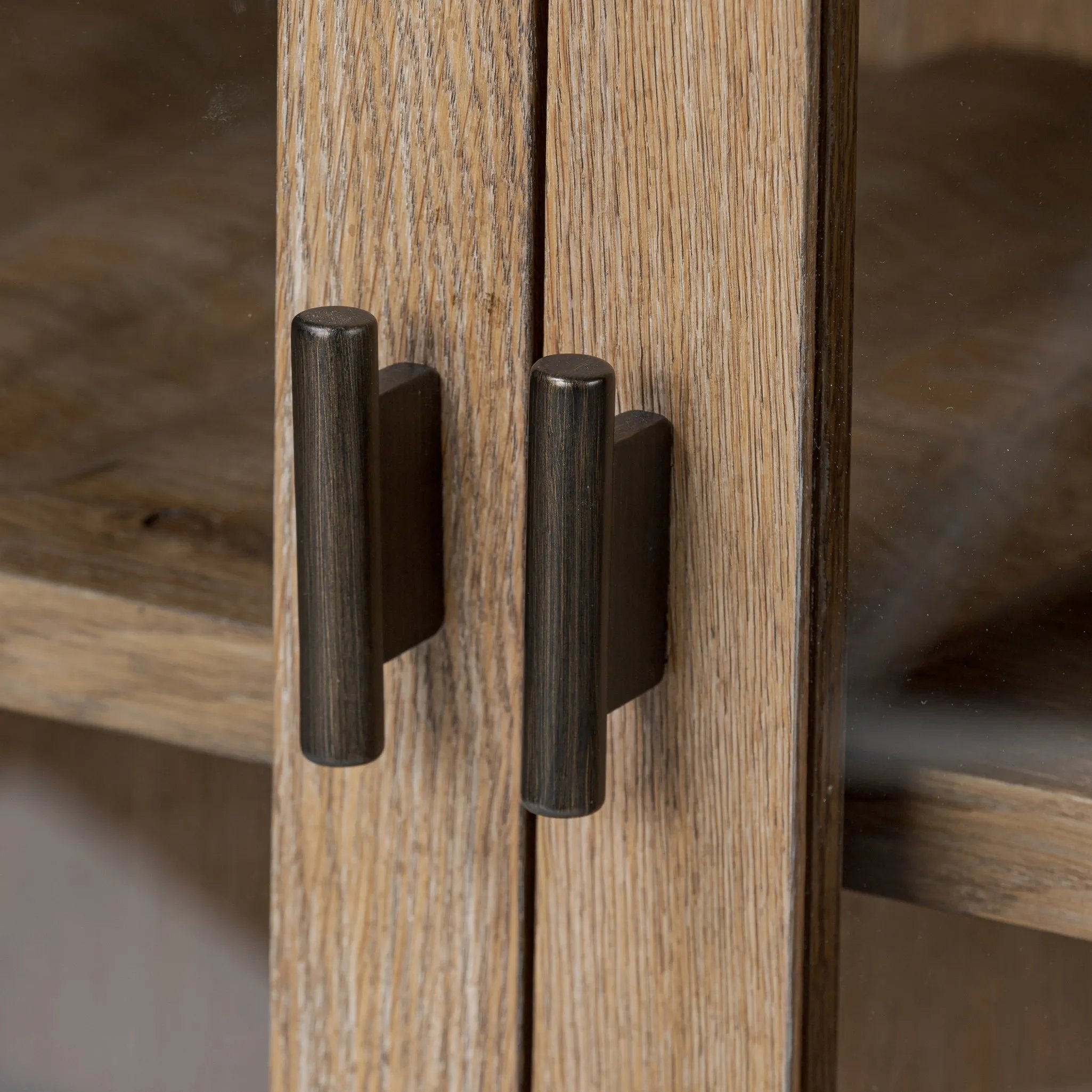 A rustic oak bar cabinet shapes subtly curved corners, bringing a handcrafted look to a minimalist form. Fixed center shelves, functional drawers and glass fronts for open display. Simple hardware is finished in an aged bronze Amethyst Home provides interior design, new home construction design consulting, vintage area rugs, and lighting in the Monterey metro area.