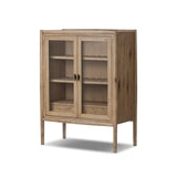 A rustic oak bar cabinet shapes subtly curved corners, bringing a handcrafted look to a minimalist form. Fixed center shelves, functional drawers and glass fronts for open display. Simple hardware is finished in an aged bronze Amethyst Home provides interior design, new home construction design consulting, vintage area rugs, and lighting in the Newport Beach metro area.