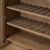 A rustic oak bar cabinet shapes subtly curved corners, bringing a handcrafted look to a minimalist form. Fixed center shelves, functional drawers and glass fronts for open display. Simple hardware is finished in an aged bronze Amethyst Home provides interior design, new home construction design consulting, vintage area rugs, and lighting in the Salt Lake City metro area.