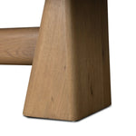 This modern take on the traditional trestle table features two angular bases, mirrored and united by softened square center beam. Dramatically angled legs pull the eye toward beautifully curved detailing. Crafted of oak with a light, natural finish. Amethyst Home provides interior design, new home construction design consulting, vintage area rugs, and lighting in the Charlotte metro area.