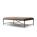 This French Industrialist-inspired cocktail ottoman features a curved stretcher base of bronzed hammered iron and a velvety seat in a versatile earth tone. Style with a sofa or sectional to create an extra surface in your living space, or for bonus seating. Amethyst Home provides interior design, new home construction design consulting, vintage area rugs, and lighting in the Laguna Beach metro area.