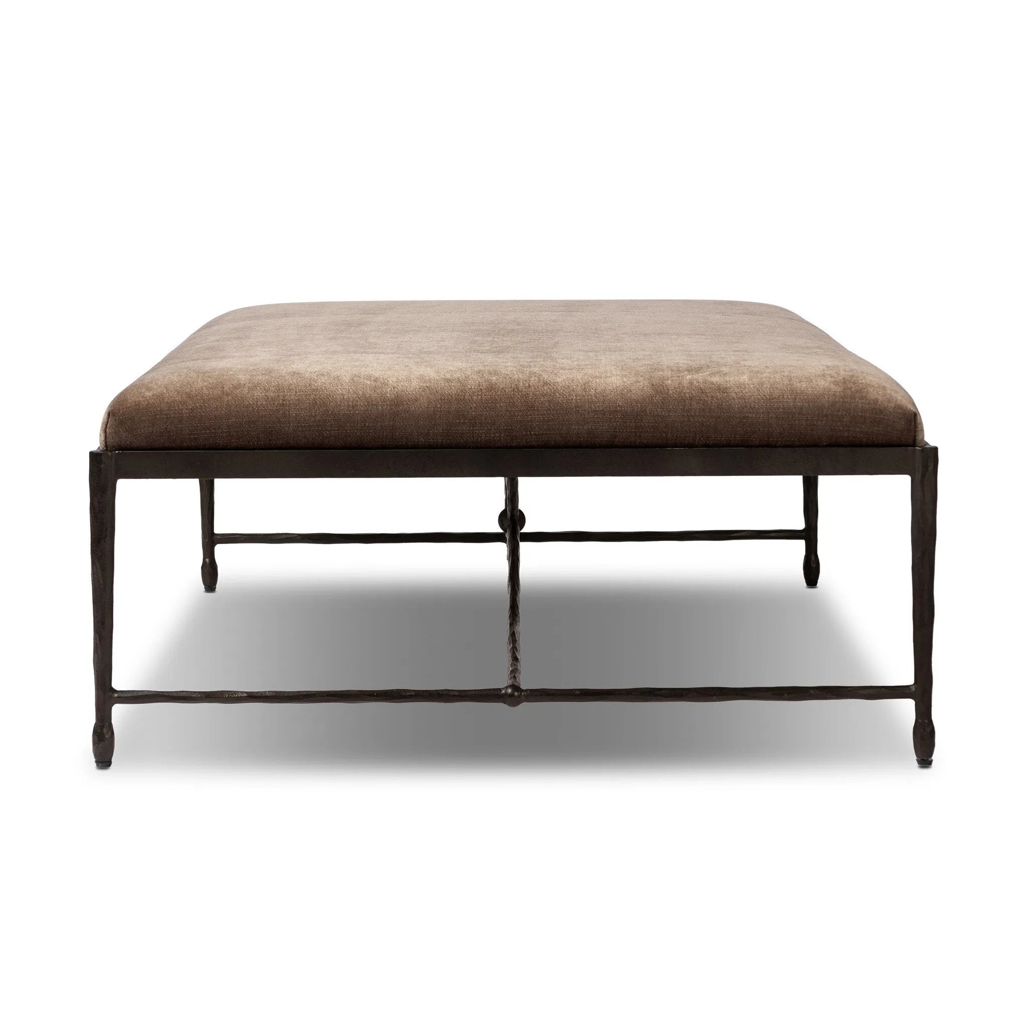 This French Industrialist-inspired cocktail ottoman features a curved stretcher base of bronzed hammered iron and a velvety seat in a versatile earth tone. Style with a sofa or sectional to create an extra surface in your living space, or for bonus seating. Amethyst Home provides interior design, new home construction design consulting, vintage area rugs, and lighting in the Winter Garden metro area.