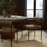 The armless dining chair gets a playful update with a bolstered cylinder seat back. Made from soft shearling and hammered met