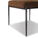 The armless dining chair gets a playful update with a bolstered cylinder seat back. Made from soft shearling and hammered met