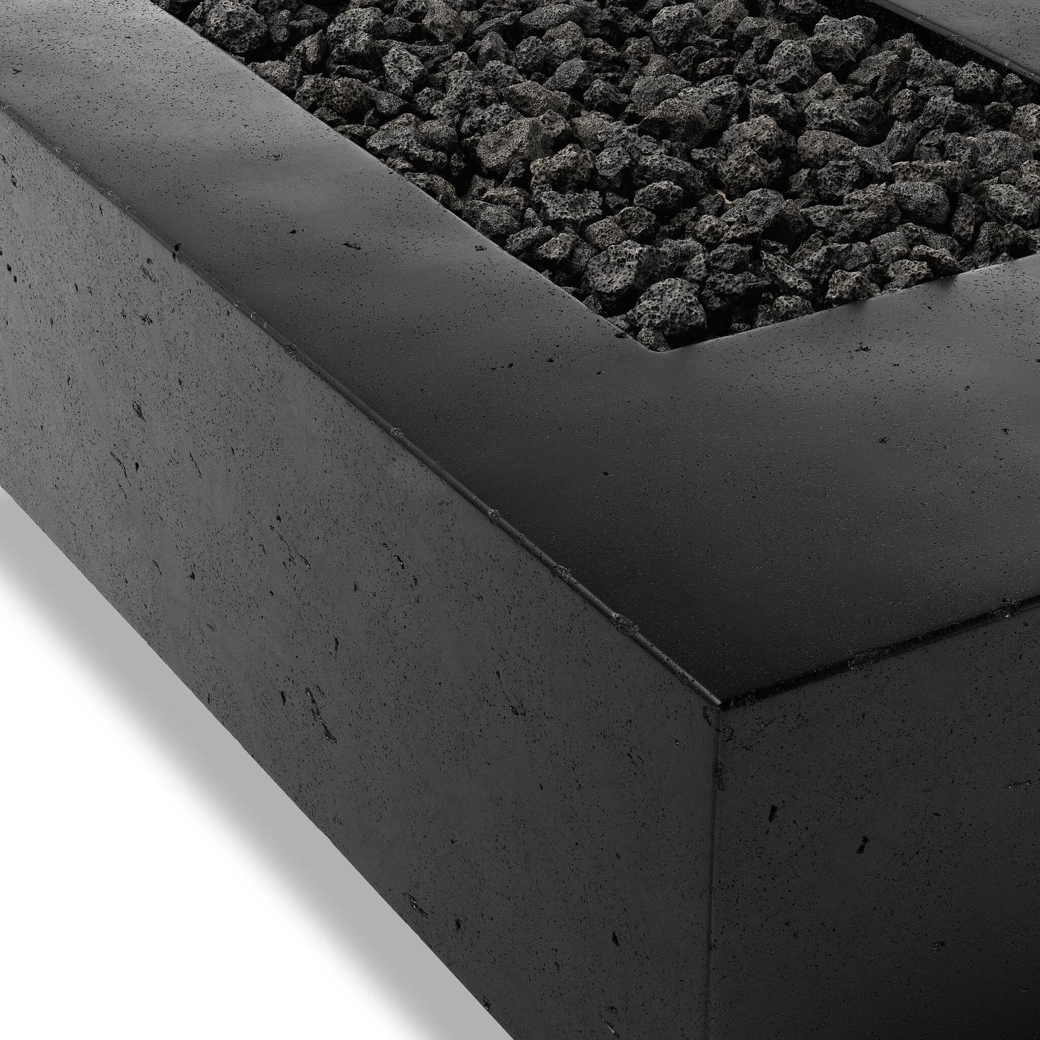 This outdoor fire table is a welcoming centerpiece designed for gathering. Made from glass-reinforced concrete, each piece is naturally finished with deep tones of charcoal. The monolithic shape is completed with lavastones in the center, bringing together a bold, monochromatic look. Amethyst Home provides interior design, new home construction design consulting, vintage area rugs, and lighting in the Alpharetta metro area.