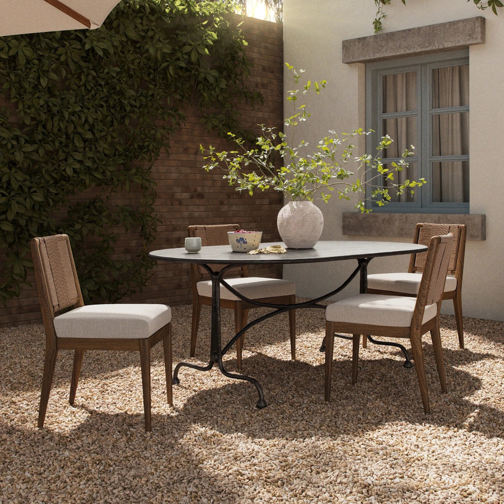 This outdoor dining table takes inspiration from French Art Deco design elements, with mirroring curves creating a sense of symmetry and fluid movement. Crafted from fully cast aluminum with a distressed bronze finish, complete with plenty of textural highs and lows to give the finish depth. Amethyst Home provides interior design, new home construction design consulting, vintage area rugs, and lighting in the Alpharetta metro area.