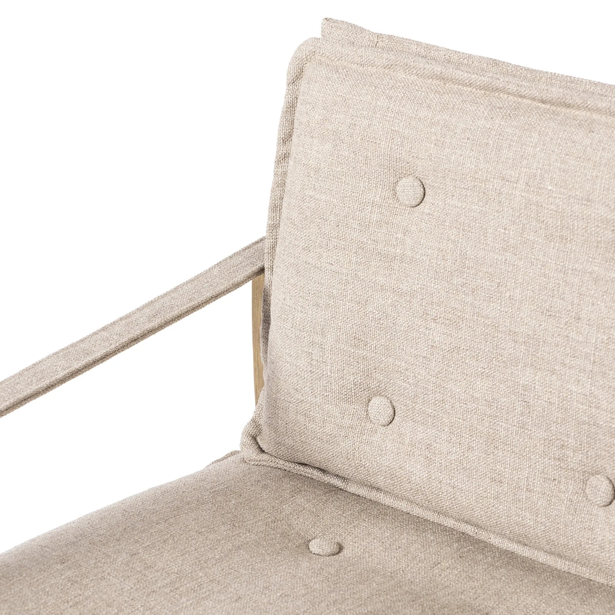 Inspired by a vintage safari-style frame, this dining chair is defined by the fluid strap arms. Semi-attached cushions in taupe performance fabric, finished with button tufting details. Framed out by warm parawood. Amethyst Home provides interior design, new home construction design consulting, vintage area rugs, and lighting in the Houston metro area.