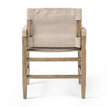 Inspired by a vintage safari-style frame, this dining chair is defined by the fluid strap arms. Semi-attached cushions in taupe performance fabric, finished with button tufting details. Framed out by warm parawood. Amethyst Home provides interior design, new home construction design consulting, vintage area rugs, and lighting in the Seattle metro area.