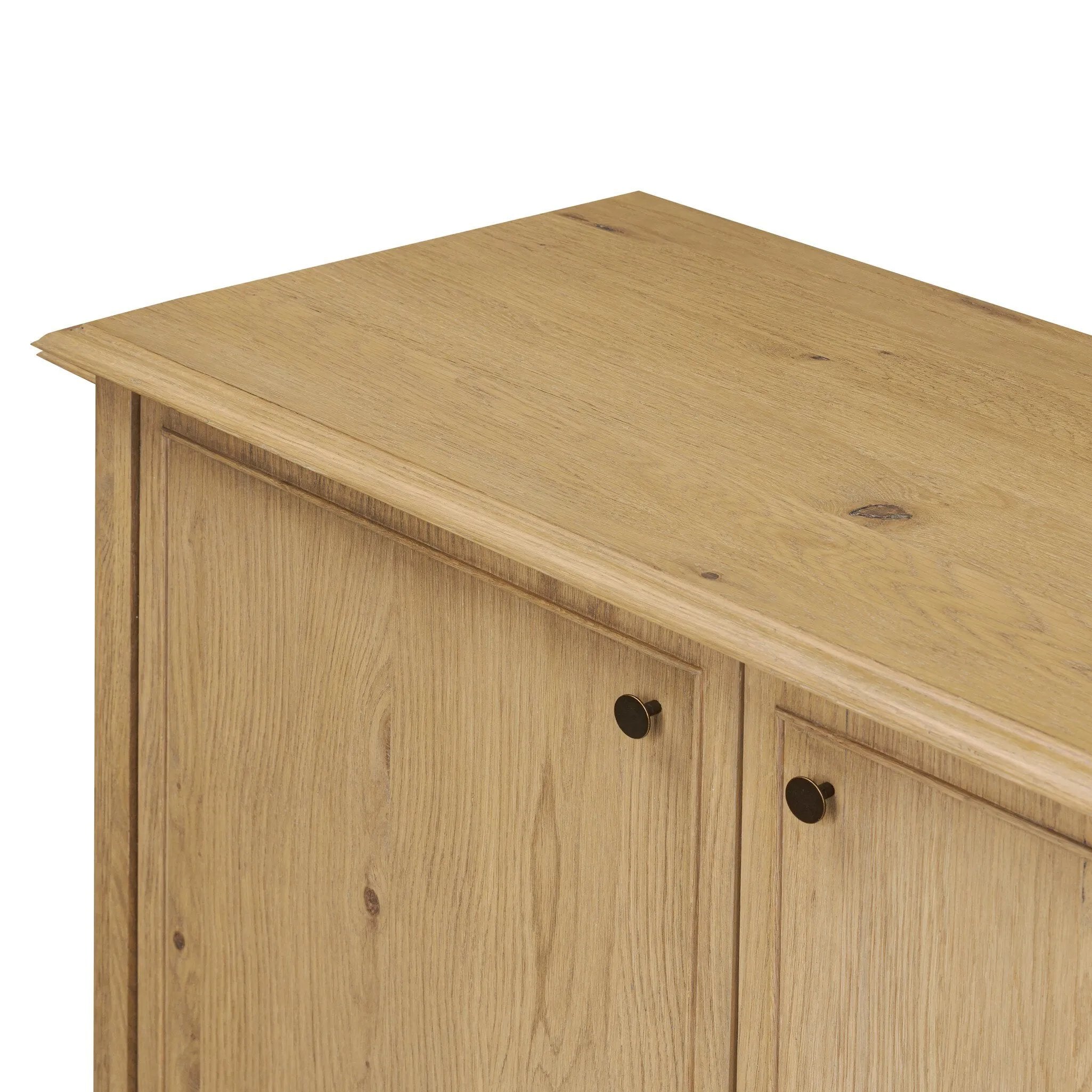 A cleanly shaped sideboard is crafted from aged smoked oak, highlighting the wood's natural grain throughout. Roomy cabinets offer plenty of storage, and the slim, tapered legs give the piece a subtle lift, creating a light but grounded look. Finished with petite bronze knobs. Amethyst Home provides interior design, new home construction design consulting, vintage area rugs, and lighting in the Austin metro area.