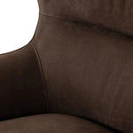 Modern wingback with a twist of barrel back design, this enveloping swivel chair comes with velvety upholstery in a deep brow