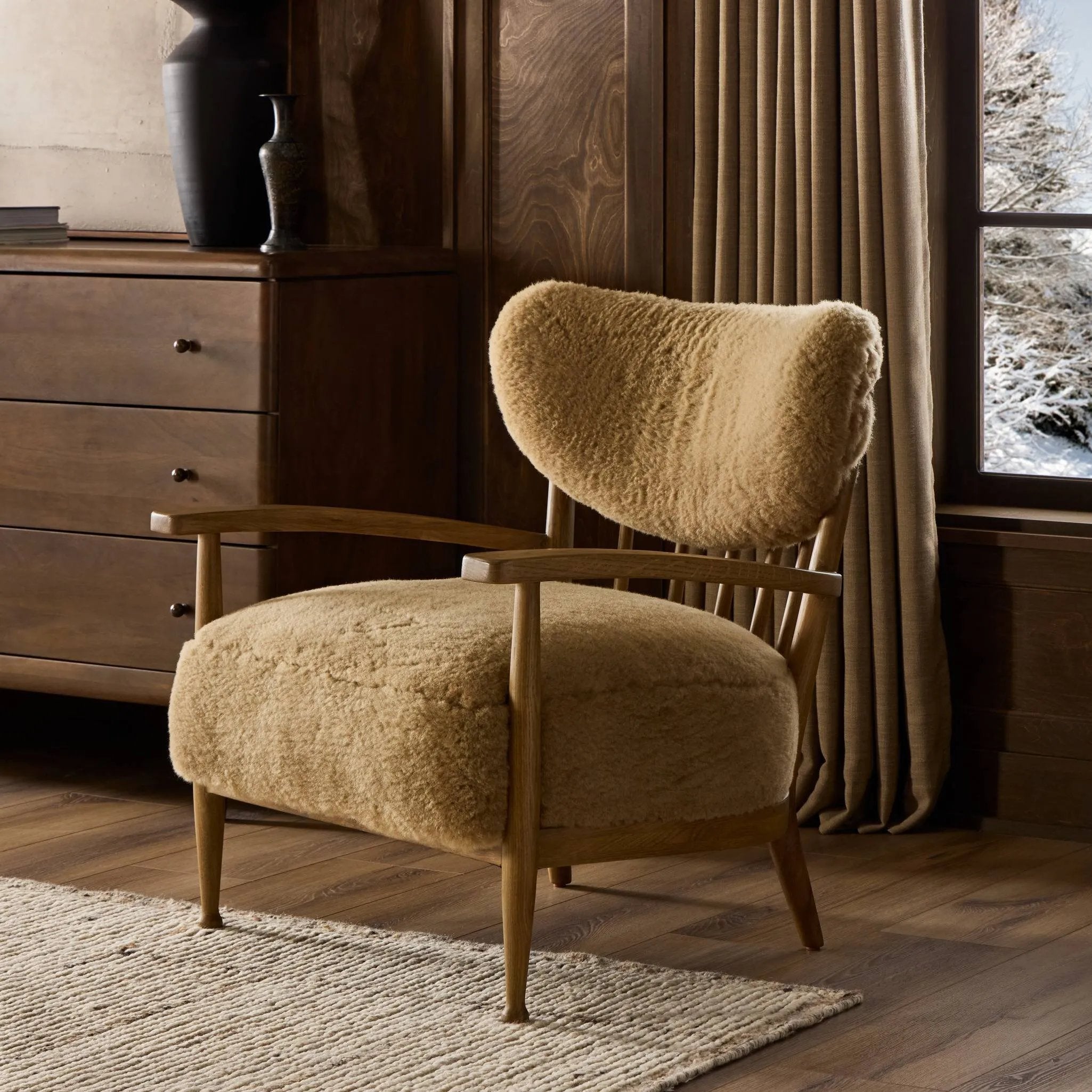 Classic Scandinavian design gets a supersoft update with a winged back panel of amber-finished oak floating above a chunky seat with exposed spindles. Paddle arms and ball feet add to the minimalist design. Covered in natural beige shearling for extra texture and comfort Amethyst Home provides interior design, new home construction design consulting, vintage area rugs, and lighting in the Park City metro area.