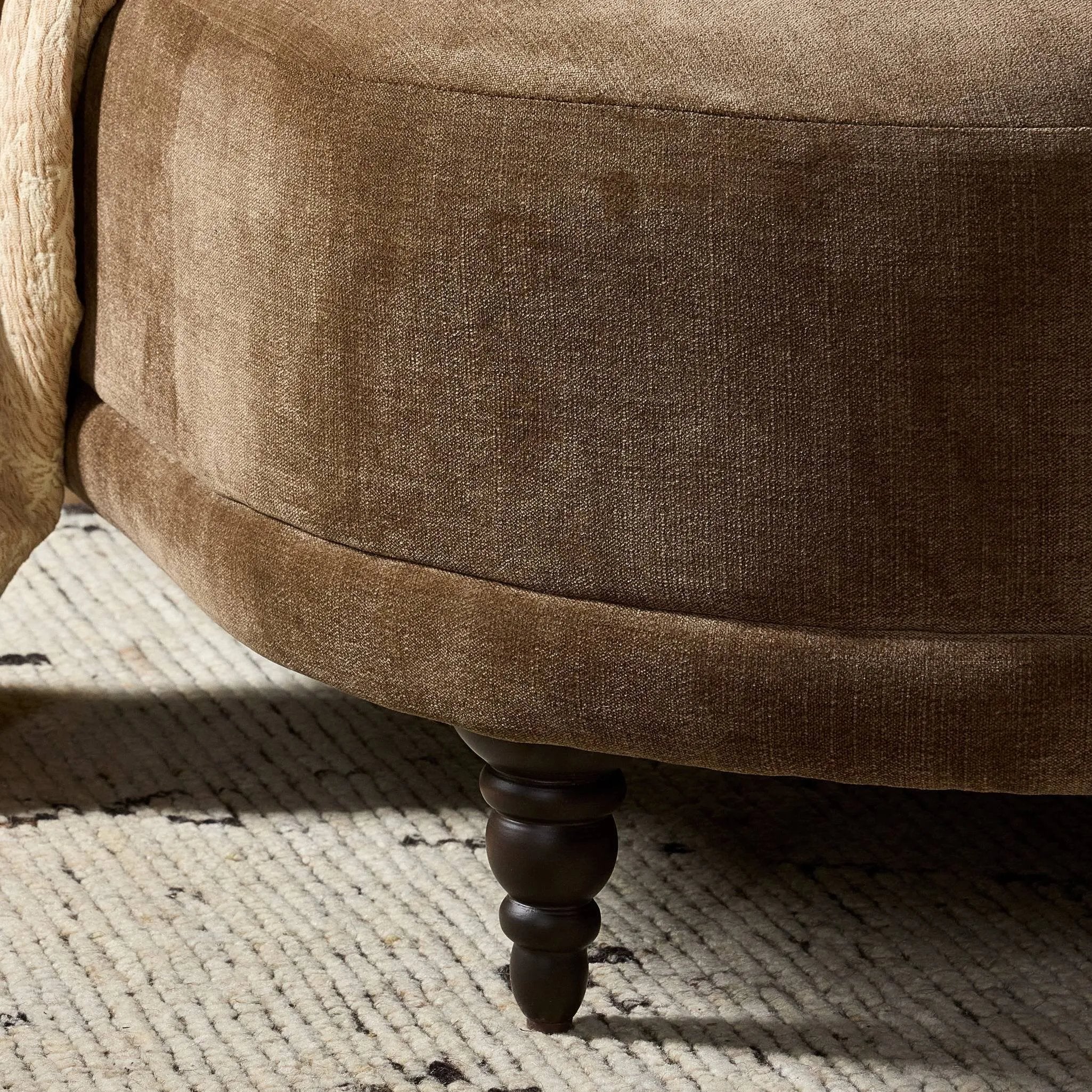 A traditional shape with modern styling, turned wooden legs complement the soft curves of this lounge-worthy chair. A chenill