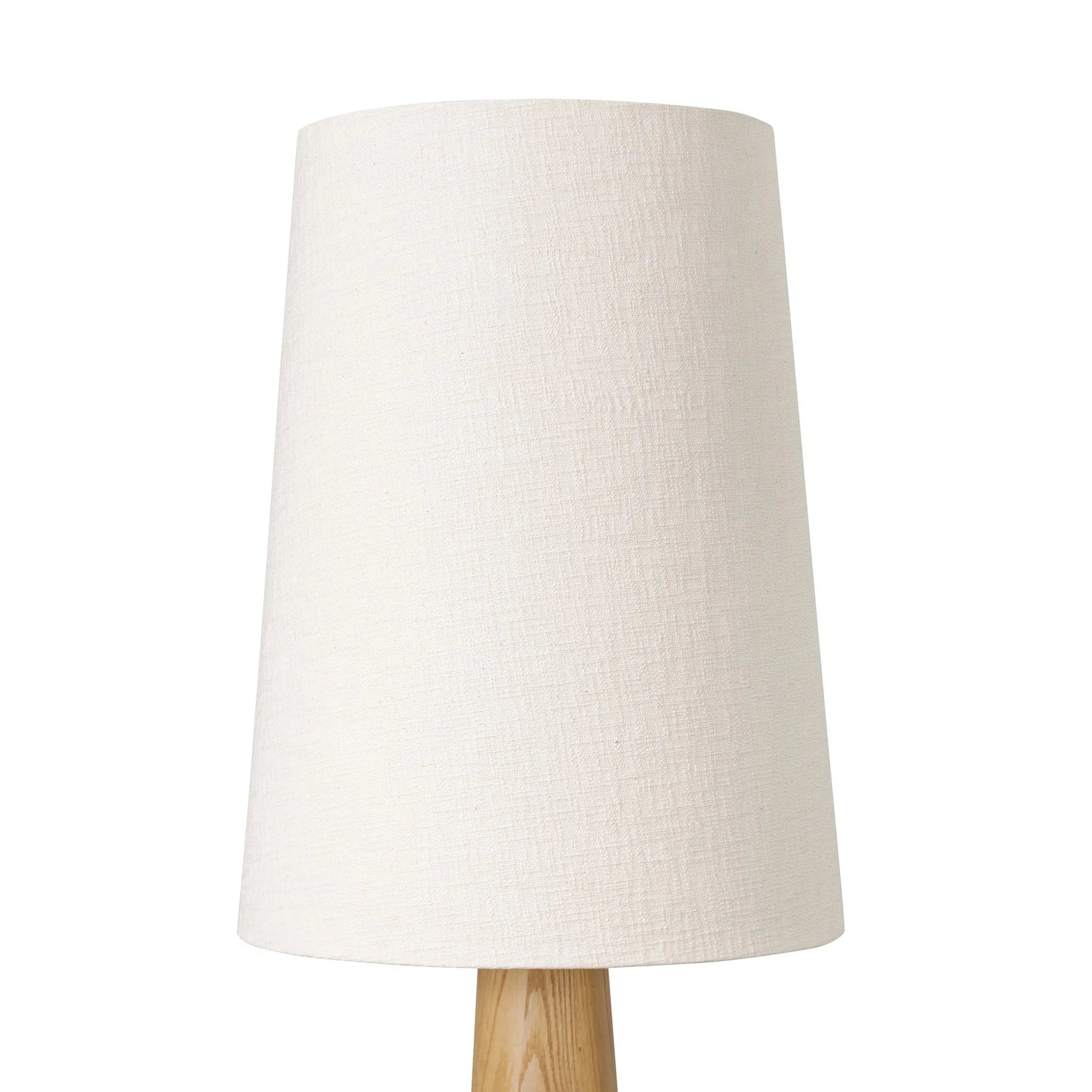 Modern minimal meets traditional. A tapered wood floor lamp base is topped with a design-forward boucle linen shade Amethyst Home provides interior design, new home construction design consulting, vintage area rugs, and lighting in the Charlotte metro area.