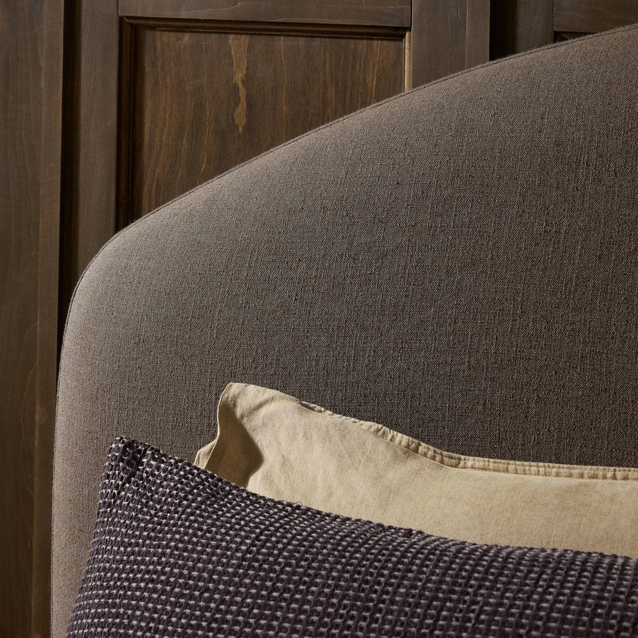 An arched headboard and simple frame act as the perfect canvas for your favorite bedding. A soft textural linen slipcover in a rich brown hue contributes a cozy yet refined look Amethyst Home provides interior design, new home construction design consulting, vintage area rugs, and lighting in the San Diego metro area.